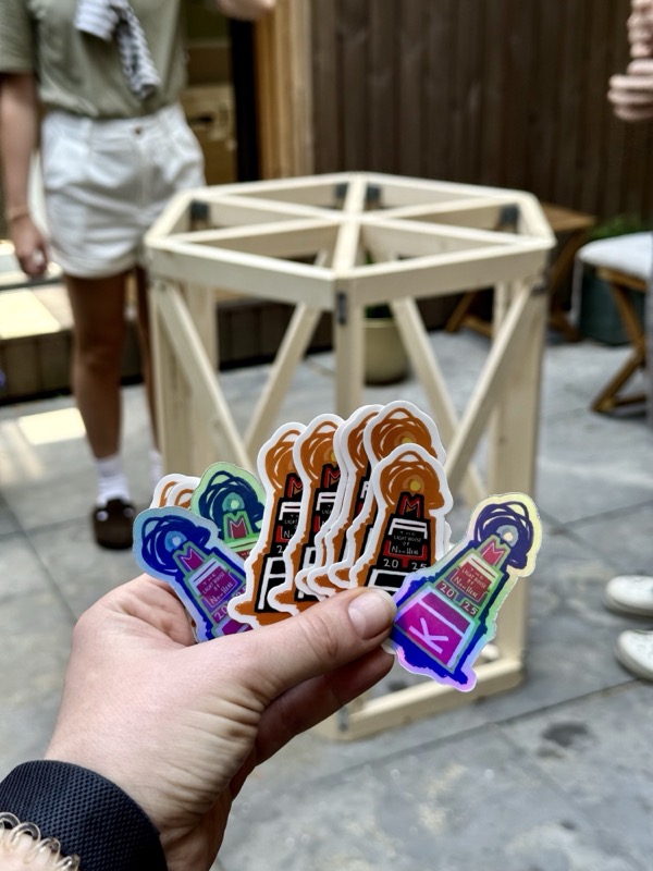 Holding stickers in front of a small wooden model