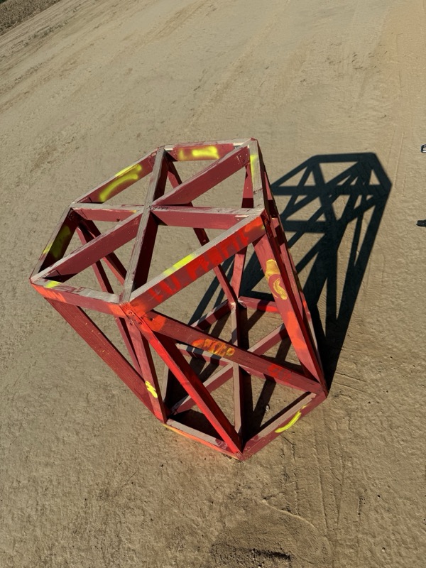 A painted frame section lying on the sand