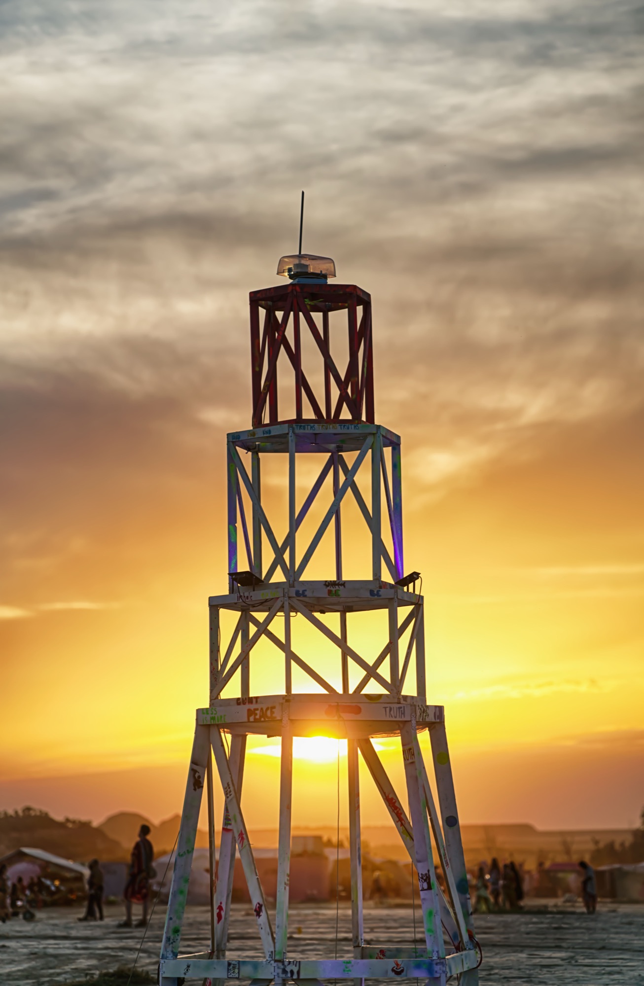 The lighthouse silhouetted against a golden sunset