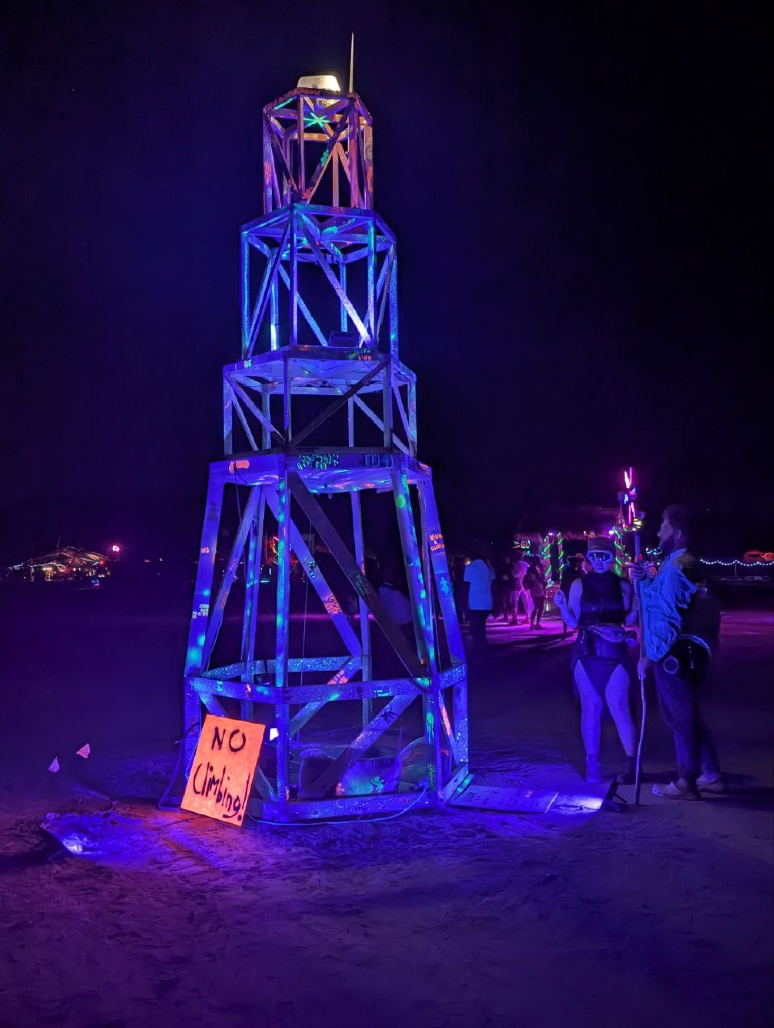 The lighthouse at night with visitors nearby